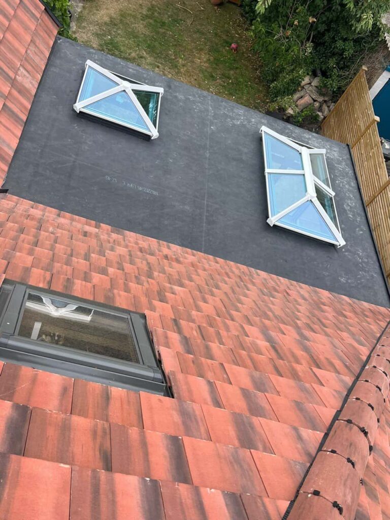 This is a photo taken from the roof ridge looking down a tiled pitched roof on to a flat roof. Works carried out by Hillfield This is a photo taken from a roof showing the hip tiles which have been removed and are just about to be repaired by Hillfield Roofing Repairs